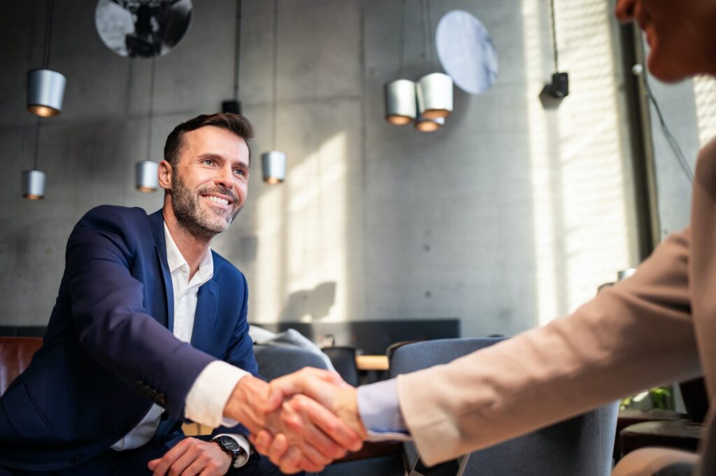 Business people shaking hands during meeting in cafe